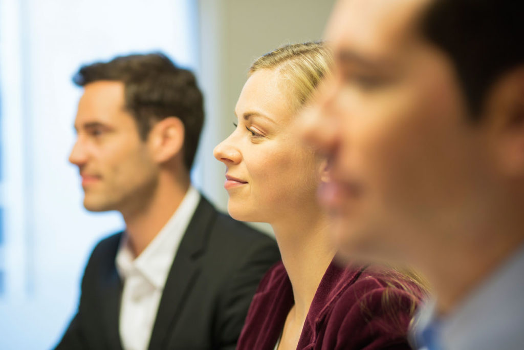 Three colleagues sitting at a business meeting, focus on pretty woman